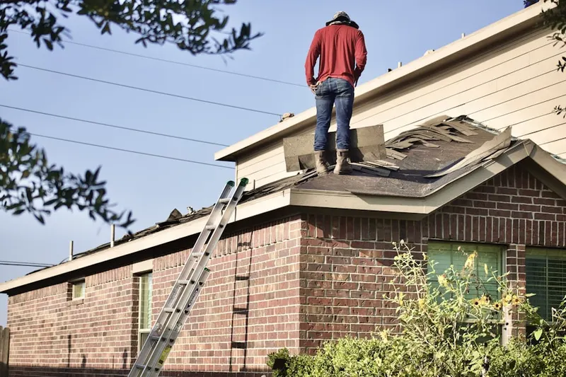 Professional roofer working on a residential roof in Mahncke Park